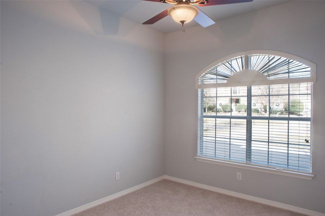 Unfurnished room with healthy amount of natural light, light carpet, baseboards, and a ceiling fan | Image 18
