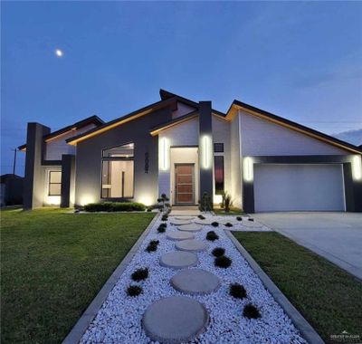 Modern home with a garage and a front lawn | Image 1