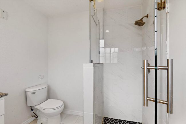 Bathroom with a shower stall and toilet | Image 23