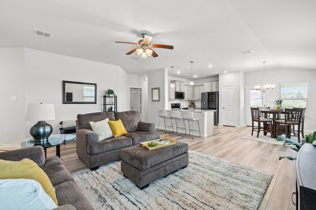 Living room with light wood-style floors, ceiling fan, a chandelier, vaulted ceiling, and recessed lighting | Image 12