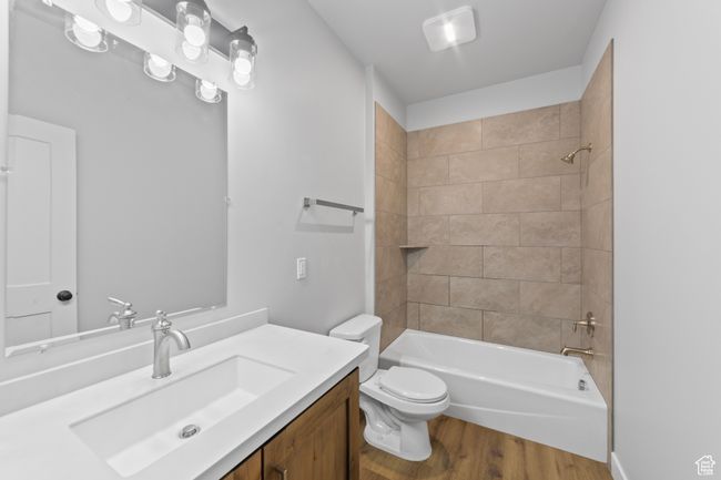 Full bath featuring toilet, vanity, washtub / shower combination, and wood finished floors | Image 23