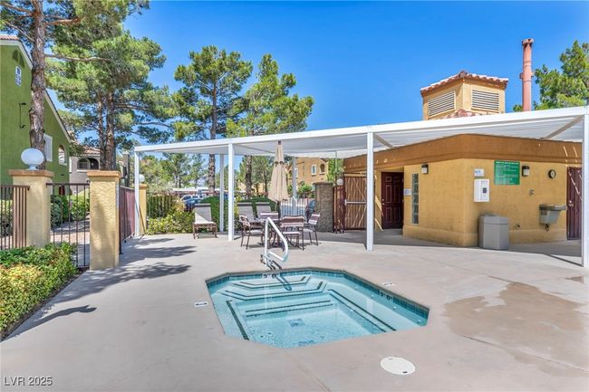 View of pool with a hot tub, a patio, and fence | Image 11