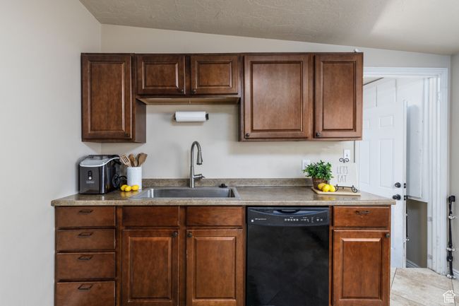 Kitchen with black dishwasher and lofted ceiling | Image 8