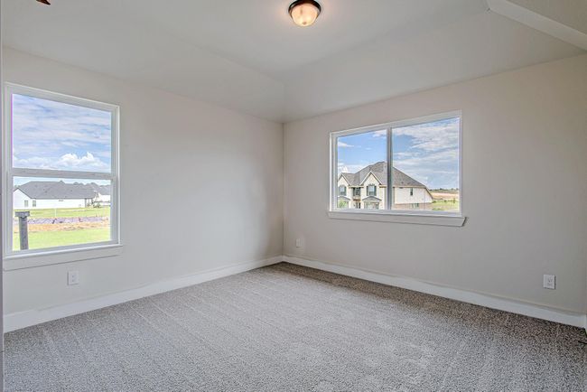 Secondary upstairs bedroom with plush carpeting, dual windows for abundant natural light, and a charming view of the neighborhood. | Image 38