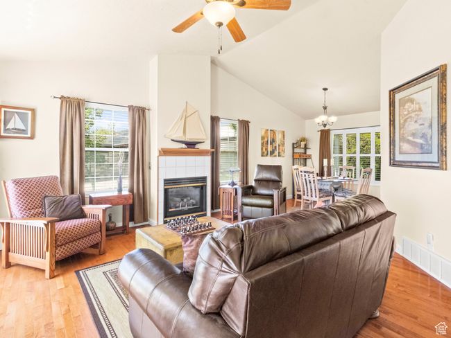 Living room with light wood floors, high vaulted ceiling, and a fireplace | Image 4