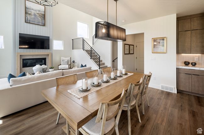 Dining area with dark wood finished floors, stairway, a large fireplace, and baseboards | Image 14
