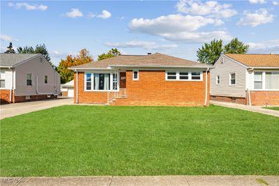 View of front of home with a front lawn and a garage | Image 1