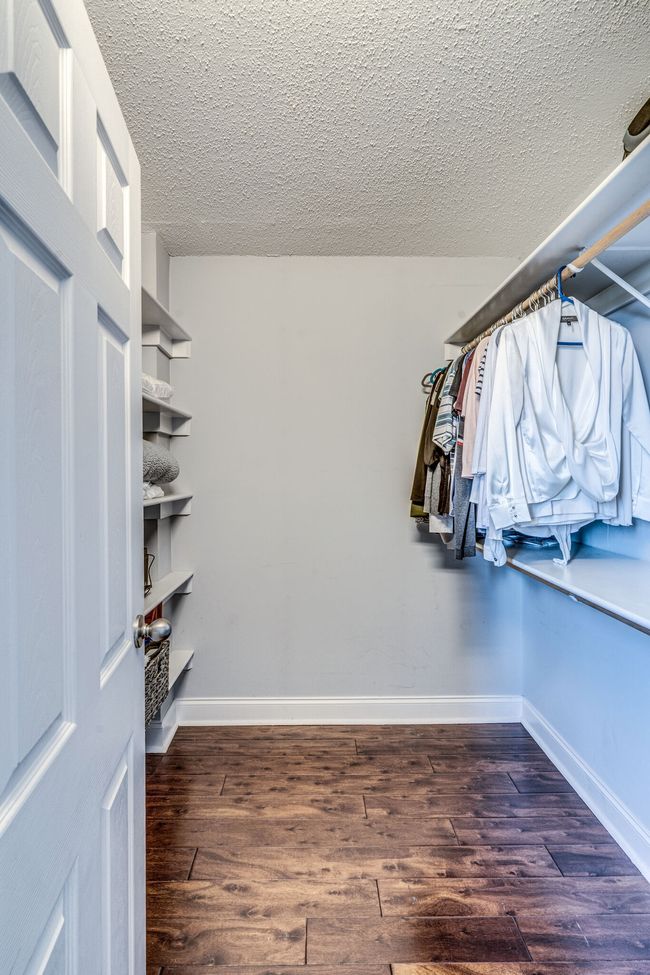 The highlight of this primary bedroom is the generously sized walk-in closet. Imagine having the luxury of a dedicated space to organize your wardrobe & accessories with ease. This closet offers thoughtful custom shelving & storage solutions. | Image 15