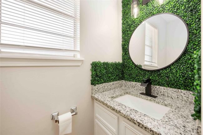 A conveniently located bathroom just off the kitchen, featuring its own vanity and toilet. | Image 19