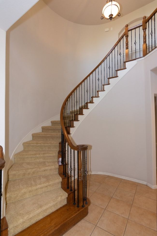 Stairway with tile patterned flooring, a towering ceiling, and baseboards | Image 15