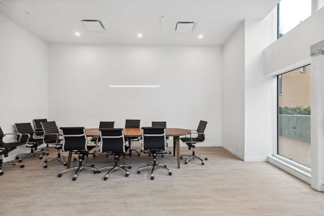 Office area with attic access, baseboards, a towering ceiling, visible vents, and wood finished floors | Image 20