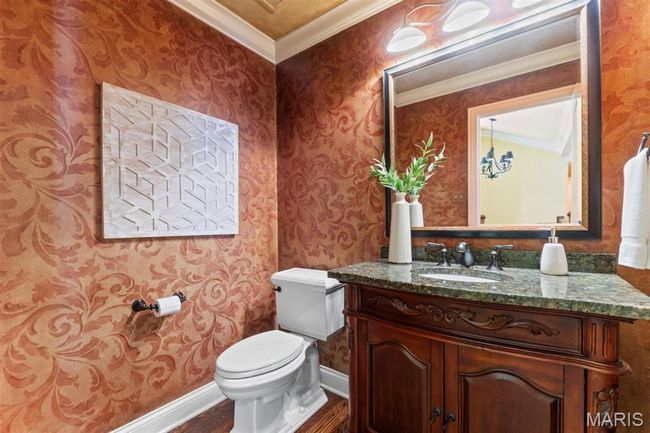 Half bath with wallpapered walls, vanity, wood finished floors, and crown molding | Image 23