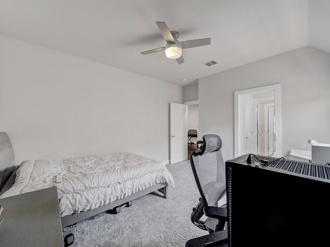 Carpeted bedroom featuring a ceiling fan and lofted ceiling | Image 21