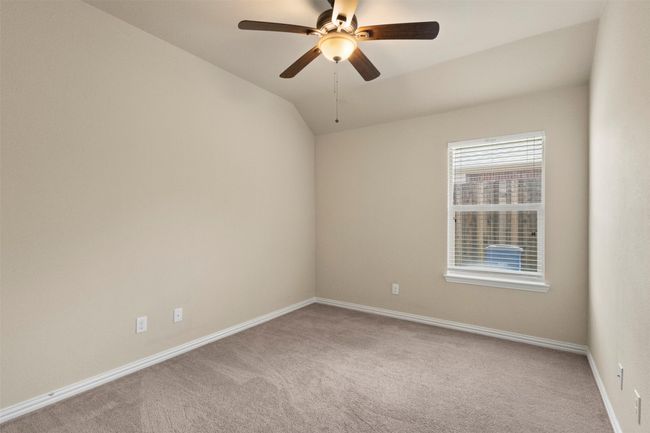 Carpeted empty room with a ceiling fan and vaulted ceiling | Image 19