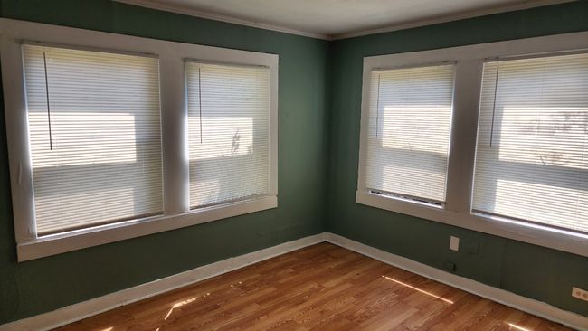 Spare room featuring baseboards, ornamental molding, and wood finished floors | Image 9