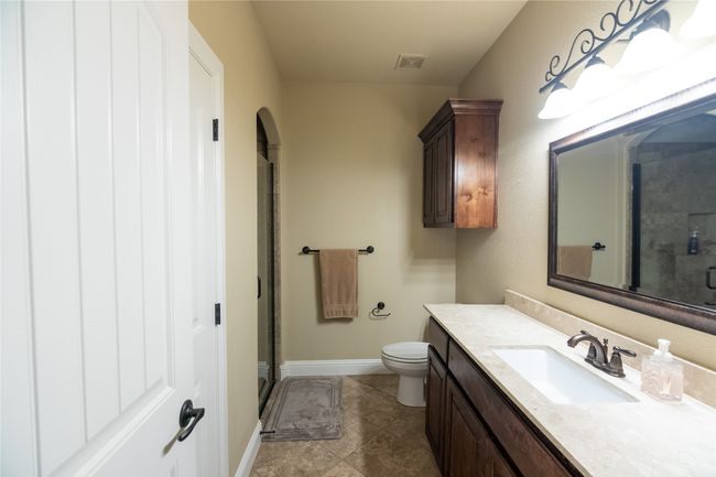 Full bathroom featuring vanity, a stall shower, toilet, tile patterned floors, and baseboards | Image 24
