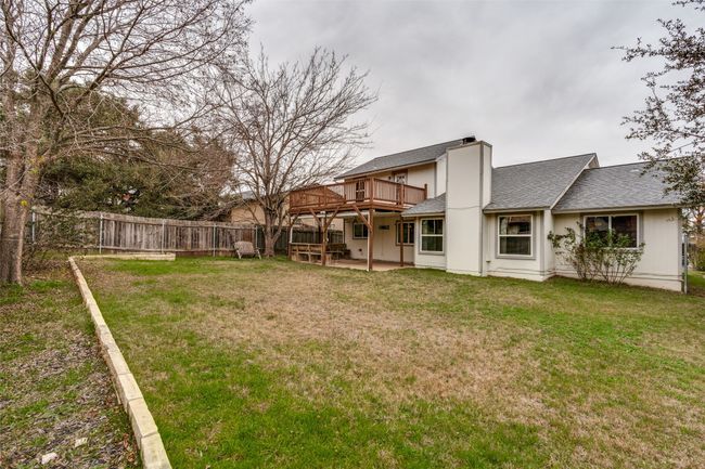 View of yard featuring a wooden deck and a patio | Image 24
