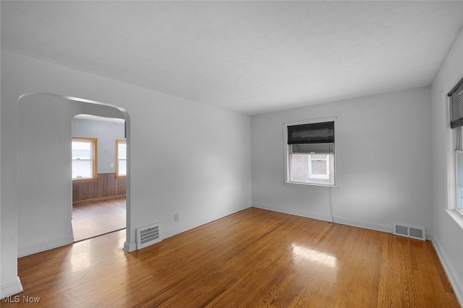 living room with visible vents, wood finished floors, and arched walkways | Image 8