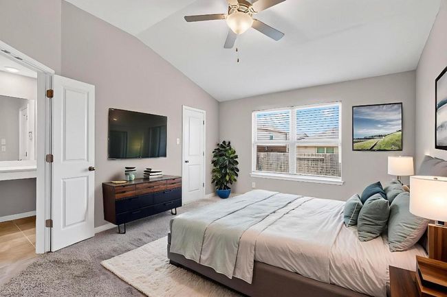 Bedroom with lofted ceiling, ceiling fan, and connected bathroom | Image 16
