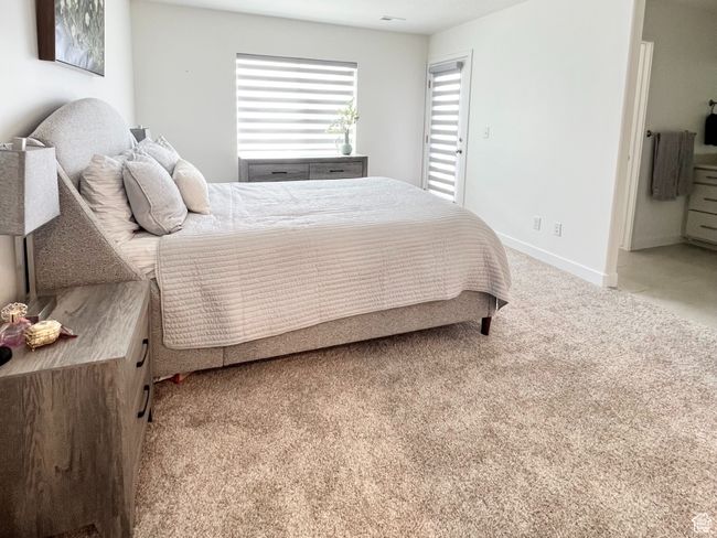 Primary Bedroom featuring light colored carpet ensuite bath walk-in closet and balcony | Image 10
