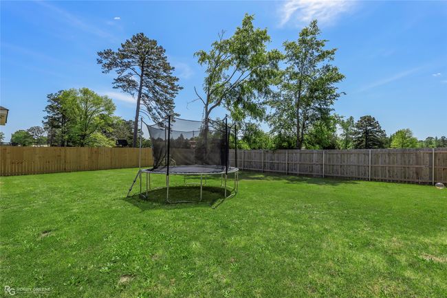 View of yard featuring a trampoline and a fenced backyard | Image 30