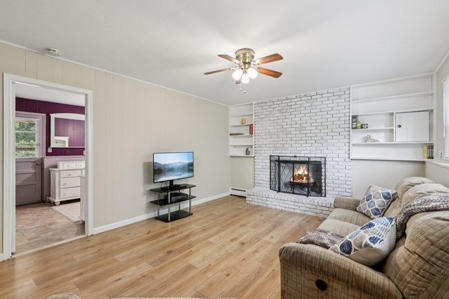 Bedroom featuring an office area, a ceiling fan, and wood walls | Image 24