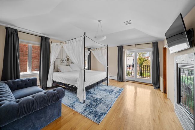 Bedroom with lofted ceiling, visible vents, light wood-style flooring, and access to exterior | Image 9