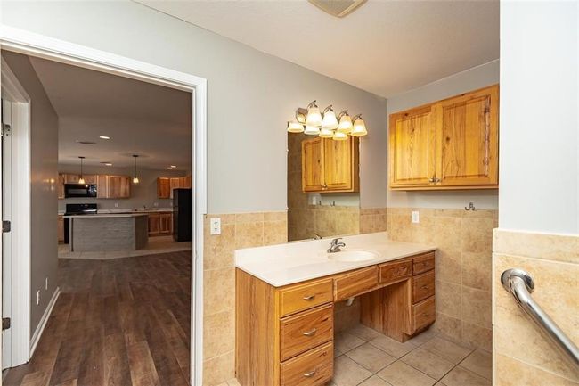 Bathroom with tile patterned floors, tile walls, wainscoting, and vanity | Image 28