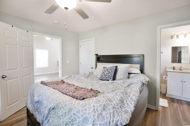 Bedroom with wood finished floors, ceiling fan, and ensuite bath | Image 19