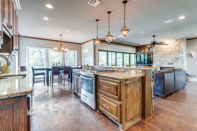 Kitchen with dark wood-type flooring, a wealth of natural light, pendant lighting, and range with gas cooktop | Image 8