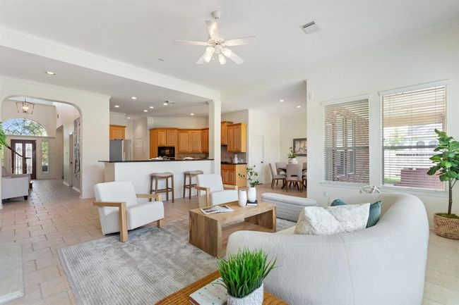 A view of the seamless flow of open-concept living, effortlessly connecting to the kitchen. Additionally the home features crown molding throughout and whole-house water softener. | Image 7