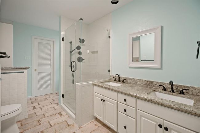 Primary ensuite with a glass enclosed walk-in shower, large soaking tub, and double sinks. | Image 17