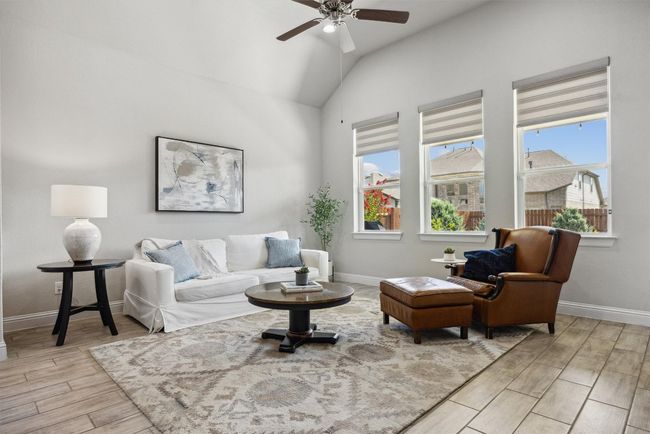 Living area featuring light wood-style flooring, a ceiling fan, and lofted ceiling | Image 13
