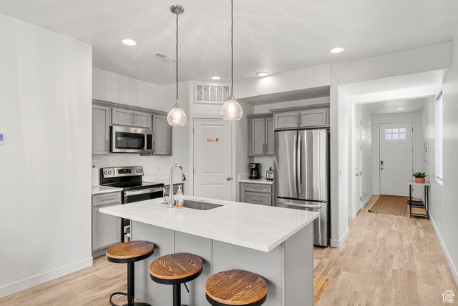 Kitchen featuring visible vents, appliances with stainless steel finishes, gray cabinetry, and a sink | Image 7