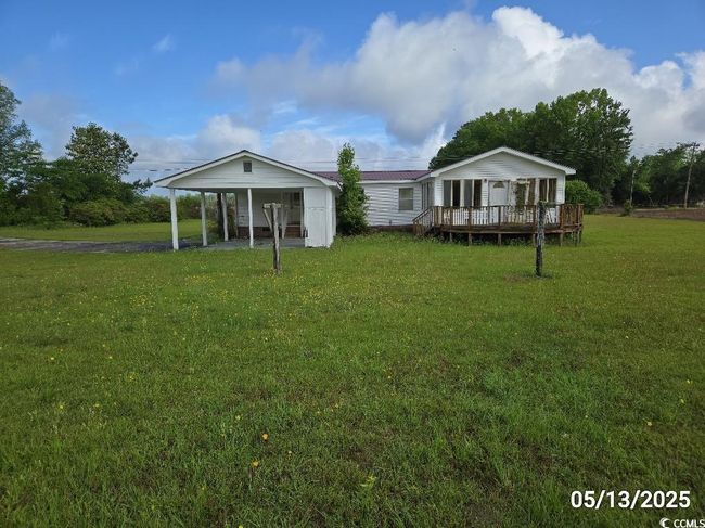 Back of property with a lawn, a wooden deck, and a carport | Image 13