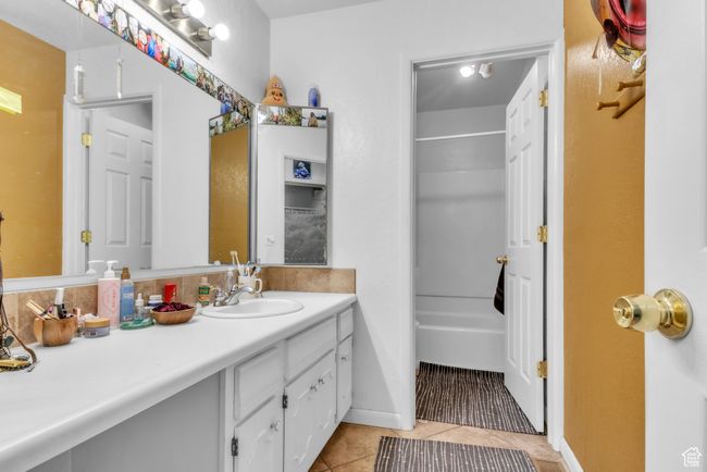 Full bath featuring vanity, tile patterned flooring, and shower / bathtub combination | Image 16