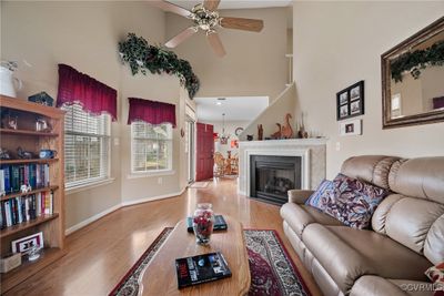 Living room with a towering ceiling, light hardwood / wood-style floors, and ceiling fan | Image 3