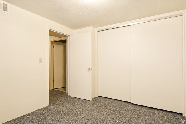 Unfurnished bedroom featuring a textured ceiling and a closet | Image 31