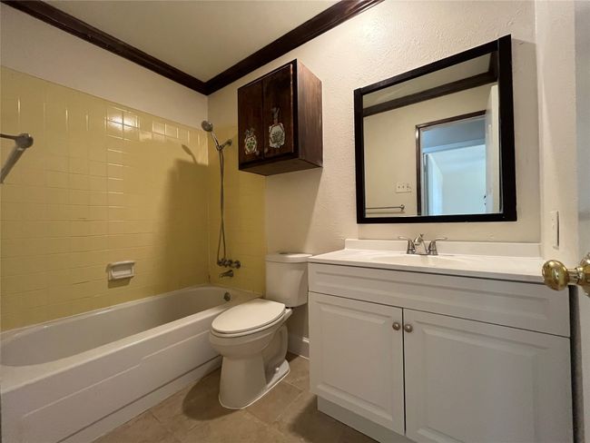 Bathroom featuring ornamental molding, toilet, shower / washtub combination, vanity, and tile patterned floors | Image 18