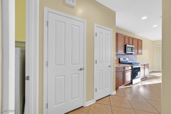 Kitchen with pantry, stainless steel appliances, light countertops, backsplash and light tile patterned flooring | Image 8
