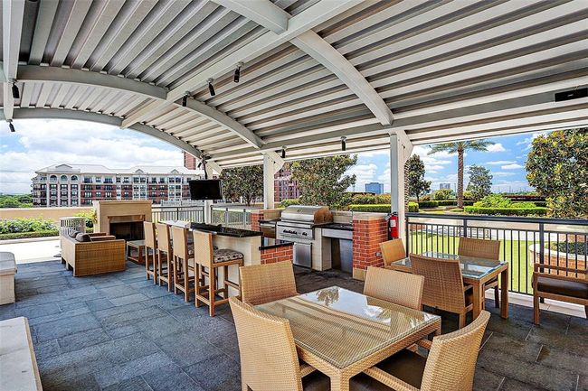 The cabana has two gas fireplaces, large grill, refrigerator, bar with counter stools, two tables for dining outdoors, and a seating area to read and relax under the covered roof....and a TV! and a sitting area. | Image 40