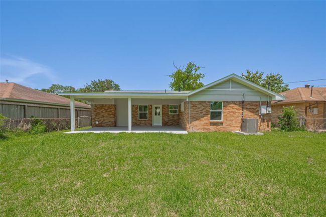 A centered view highlights the large patio and full stretch of backyard greenery, ideal for outdoor living. | Image 30