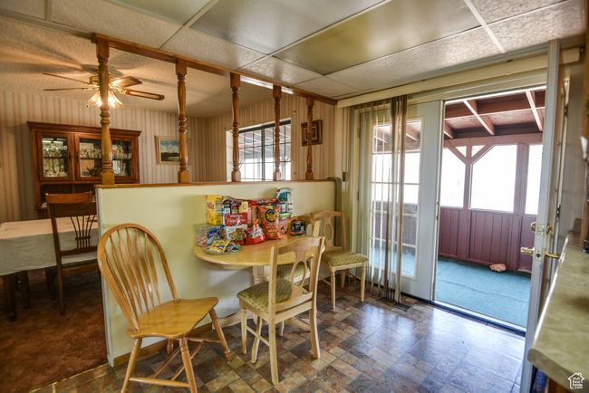 Dining room featuring ceiling fan and wooden walls | Image 28