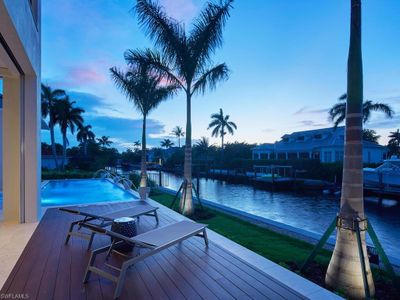 Deck at dusk featuring a water view and a dock | Image 3