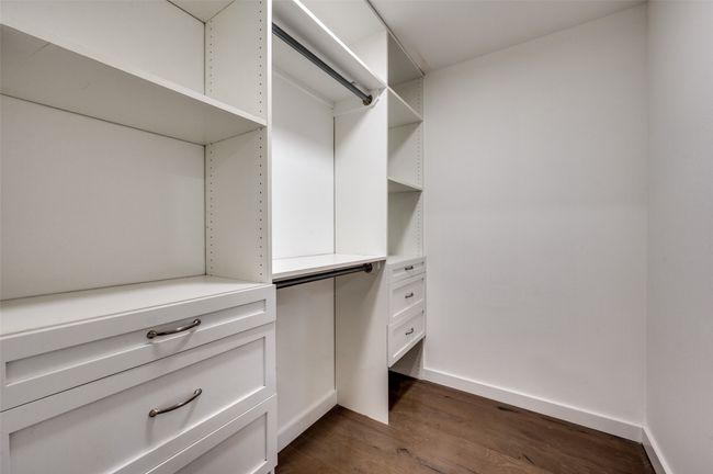 Walk in closet featuring dark wood-style floors | Image 20