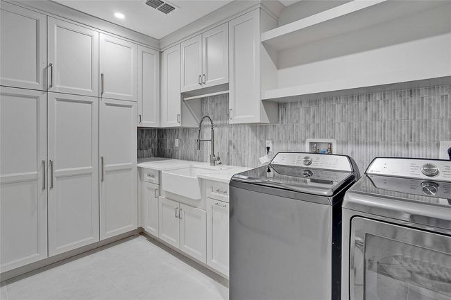 Expansive Laundry Room Featuring a Utility Sink and Storage | Image 16