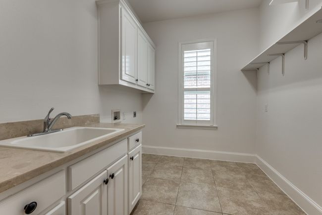 Laundry area with a sink, hookup for a washing machine, baseboards, electric dryer hookup, and cabinet space | Image 22