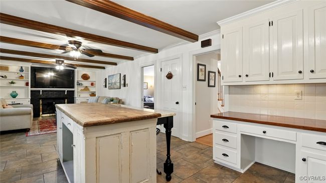 Kitchen featuring butcher block countertops, ceiling fan, backsplash, stone tile floors, and beam ceiling | Image 40
