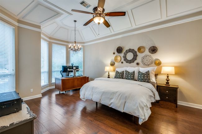Bedroom featuring coffered ceiling, a chandelier, baseboards, dark wood-type flooring, and crown molding | Image 19