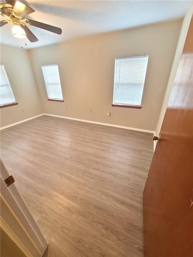 Spare room featuring ceiling fan and wood finished floors | Image 11